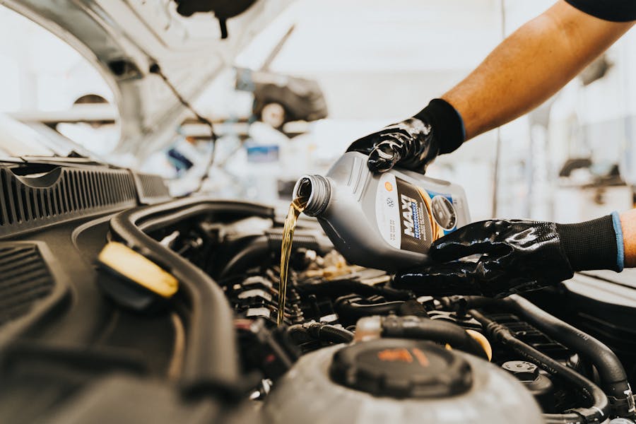 Mechanic pouring fresh oil during an oil change service at Kubin Automotive
